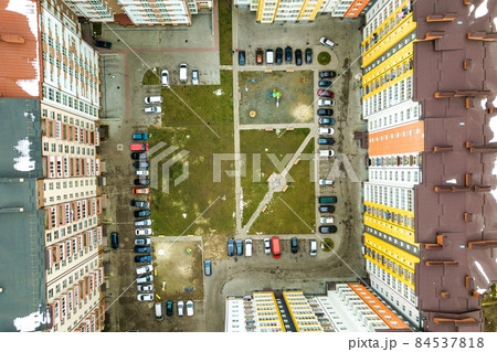 Aerial view of parked cars on parking lot between high apartment buildings. Aerial view of parked cars on parking lot between high apartment buildings. 84537818