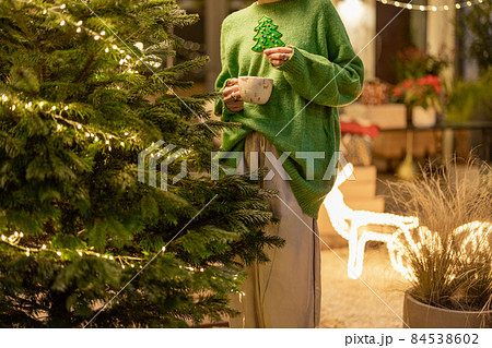 Woman holds gingerbread in a form of Christmas tree 84538602