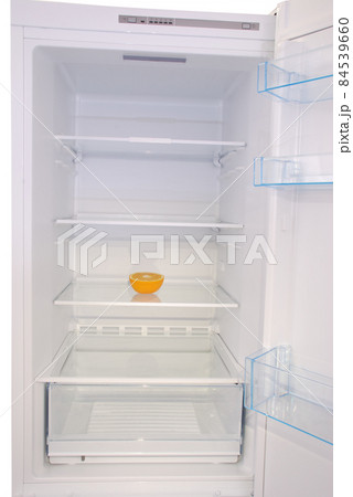 One orange in open empty refrigerator. 84539660