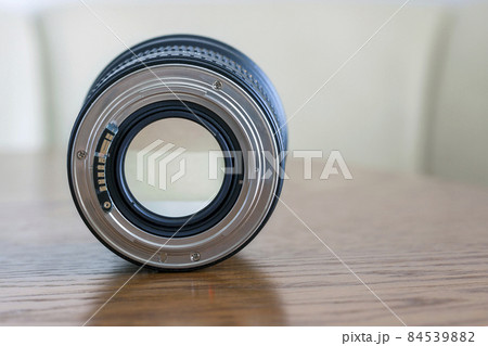 Professional Photography Equipment, Photographer Work Kit. Close-up macro shot of photo camera objective lens on wooden table. Shallow DOF Professional Photography Equipment, Photographer Work Kit. Close-up macro shot of photo camera objective lens on wooden table. Shallow DOF 84539882
