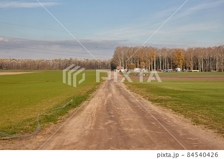 Agircutural field with dirt road Agircutural field with dirt road 84540426