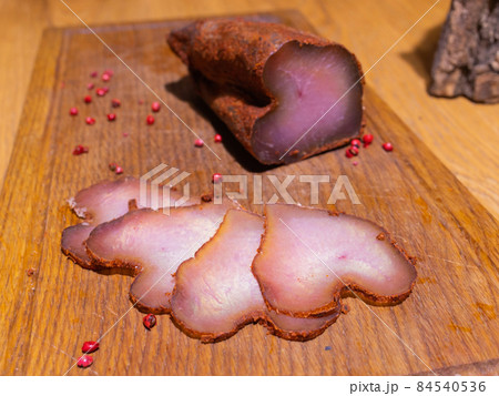 Sliced smoked gammon on a wooden table with addition of fresh herbs and aromatic spices. Sliced smoked gammon on a wooden table with addition of fresh herbs and aromatic spices. 84540536