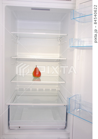 One pear in open empty refrigerator. 84540622