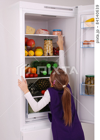 Beautiful girl near the Fridge with healthy food. Beautiful girl near the Fridge with healthy food. 84540639