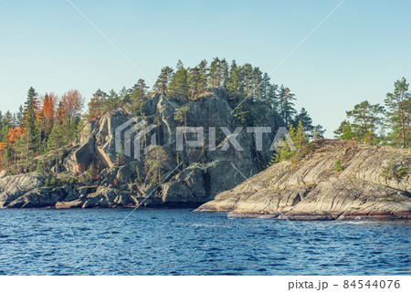Trees on the cliffs of Lake Ladoga at autumn evening. Republic of Karelia. Trees on the cliffs of Lake Ladoga at autumn evening. Republic of Karelia. 84544076