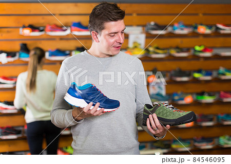 Nice man chooses shoes in shop 84546095
