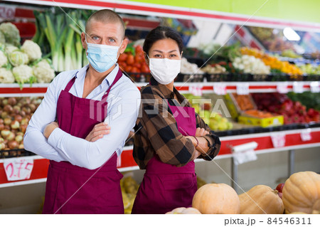 Greengrocer workers in masks standing in salesroom Greengrocer workers in masks standing in salesroom 84546311