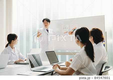 会議する白衣姿の男女 84547601