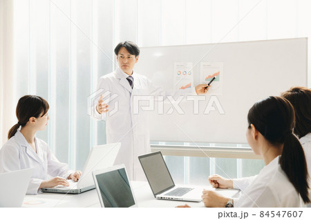 会議する白衣姿の男女 84547607