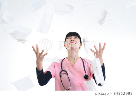 不織布マスクを投げる医療従事者の女性　コロナ禍の終息　マスク不要の社会 84552995