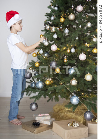 Boy with gifts plays near the Christmas tree Boy with gifts plays near the Christmas tree 84553982