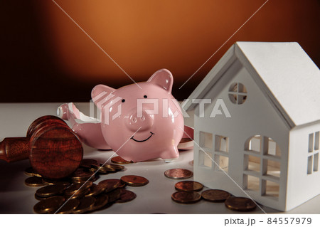 Wooden gavel, broken piggy bank with coins and house. Auction and bankruptcy concept 84557979
