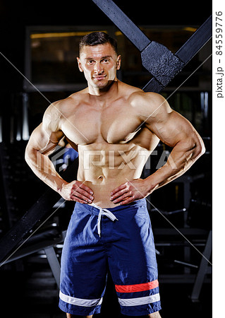 Young bodybuilder with great muscles posing in gym 84559776