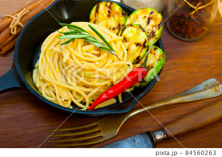 italian spaghetti pasta with zucchini sauce on iron skillet 84560263