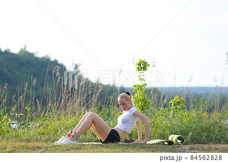 Beautiful female doing press exercises outside Beautiful female doing press exercises outside 84562828