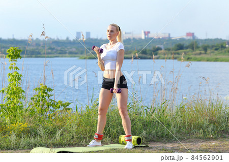 Athlete female weighted arm legs workout outdors Athlete female weighted arm legs workout outdors 84562901