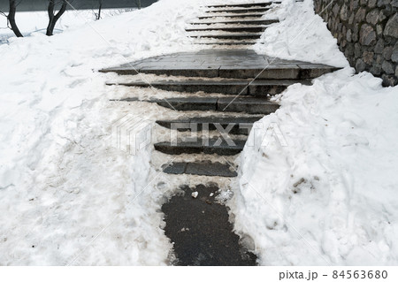 Concrete stone staircase covered with dirty deep slippery snow after blizzard snowstorm snowfall at city pedestrian walkway. Slide fall injury danger slip steps. Winter cold season weather Concrete stone staircase covered with dirty deep slippery snow after blizzard snowstorm snowfall at city pedestrian walkway. Slide fall injury danger slip steps. Winter cold season weather 84563680