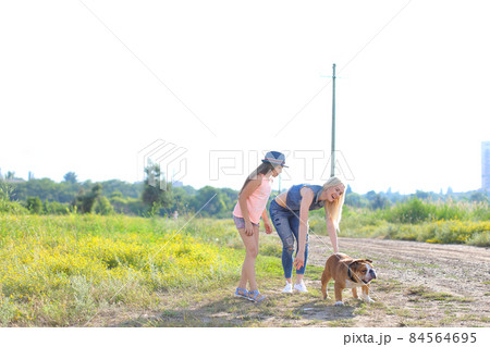 Girl female playing with friend american bulldog running Girl female playing with friend american bulldog running 84564695