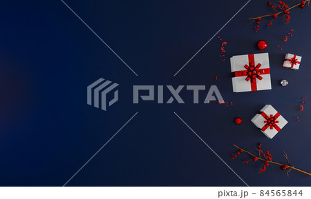New Year and Christmas dark blue background with decoration on side mockup. Flay lay. Top view. Christmas tree, ornaments, gift boxes, presents, candy canes. Holiday concept. 3d illustration. 84565844