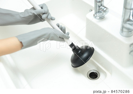 排水溝の詰まりをラバーカップで解消する主婦の手 排水溝の詰まりをラバーカップで解消する主婦の手 84570286