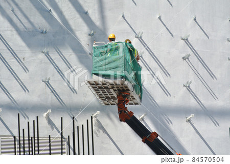 JOHOR, MALAYSIA -JANUARY 20, 2016: Construction workers standing in the sky lift bucket while working at high level in the construction site in Malaysia.    84570504