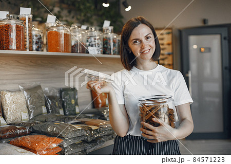 Beautiful woman in the store buys groceries. Beautiful woman in the store buys groceries. 84571223