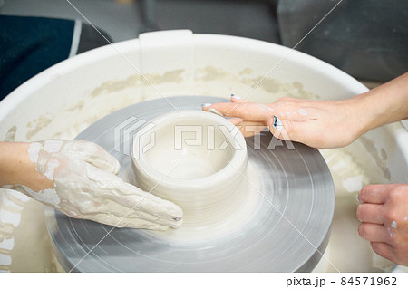 Woman making ceramic pottery, four hands close-up, focus on potters, palms with pottery Woman making ceramic pottery, four hands close-up, focus on potters, palms with pottery 84571962