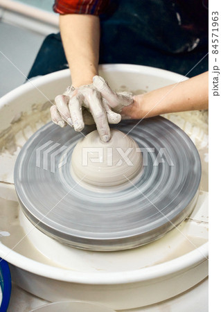 Woman making ceramic pottery, four hands close-up, focus on potters, palms with pottery Woman making ceramic pottery, four hands close-up, focus on potters, palms with pottery 84571963