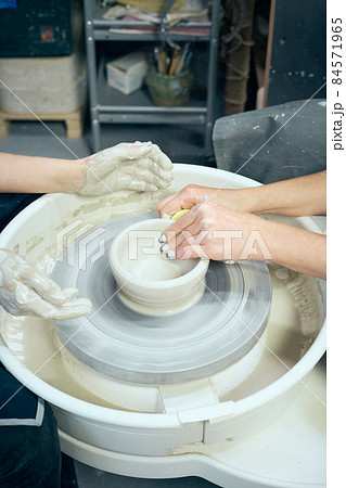 Woman making ceramic pottery, four hands close-up, focus on potters, palms with pottery 84571965