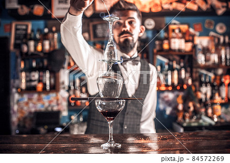 Confident bartending creates a cocktail at the bar counter Confident bartending creates a cocktail at the bar counter 84572269