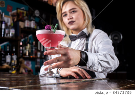 Girl bartender mixes a cocktail on the taproom Girl bartender mixes a cocktail on the taproom 84573739