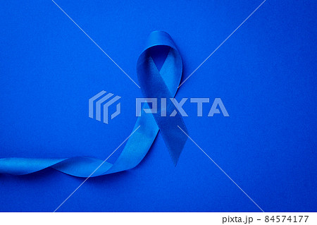 Cancer awareness blue. Awareness of men health in November with blue prostate cancer ribbon isolated on deep blue background. November and International Mens Day. Cancer awareness blue. Awareness of men health in November with blue prostate cancer ribbon isolated on deep blue background. November and International Mens Day. 84574177