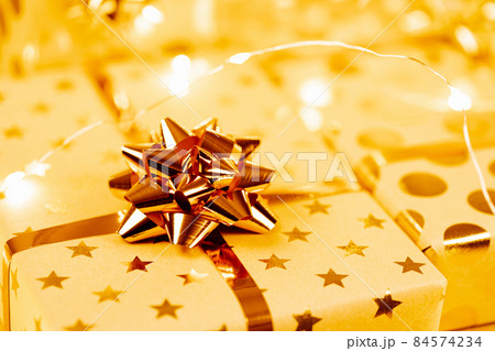 Wrapped Christmas gift boxes with golden bows and ribbon. 84574234