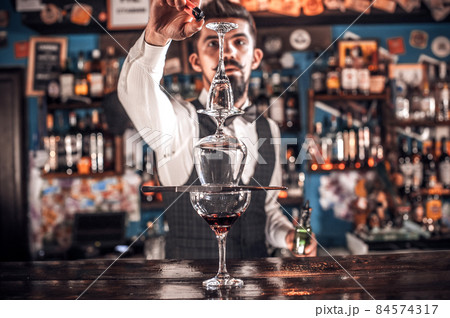Bartender concocts a cocktail in the porterhouse 84574317