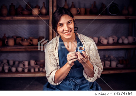Beautiful craftsman master molding a vase of clay on a potter's wheel. Handcraft. 84574364