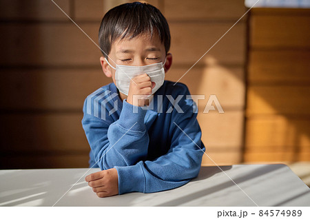 風邪をひいて咳をする小学生の男の子 84574989