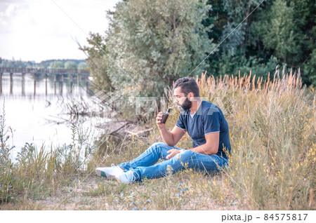 Confident smoker enjoying electronic smoke device. Getting rid of nicotine addiction. Confident smoker enjoying electronic smoke device. Getting rid of nicotine addiction. 84575817