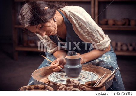 Charming female master working with pottery at the ceramic workshop. Handwork. 84575889