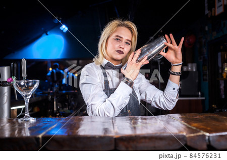 Girl barman formulates a cocktail in the public house 84576231