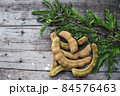 Tamarind and leaves on wood background 84576463