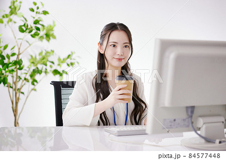 オフィスで仕事をする若い女性 オフィスで仕事をする若い女性 84577448
