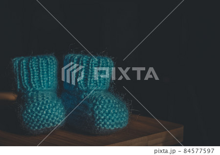 A pair of blue booties for a small child. Early morning, light from the window. A pair of blue booties for a small child. Early morning, light from the window. 84577597