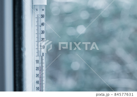 Sub-zero temperature on the thermometer outside the window. Winter. Selective focus. Sub-zero temperature on the thermometer outside the window. Winter. Selective focus. 84577631