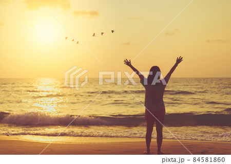Copy space of woman raise hand up on sunset sky at beach and island background. Copy space of woman raise hand up on sunset sky at beach and island background. 84581860