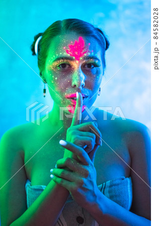 Portrait of beautiful woman painted in fluorescent powder and paint. 84582028