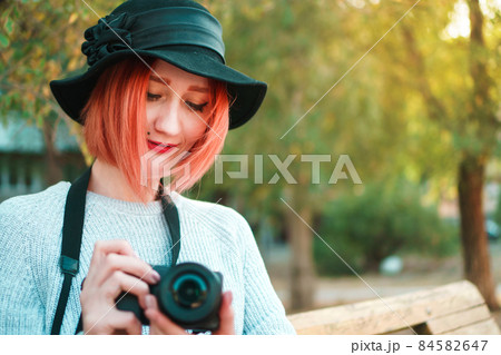 Young woman with camera in hands. Young woman with camera in hands. 84582647