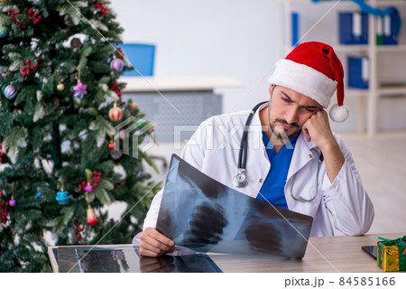 Young male doctor celebrating Christmas at the hospital Young male doctor celebrating Christmas at the hospital 84585166