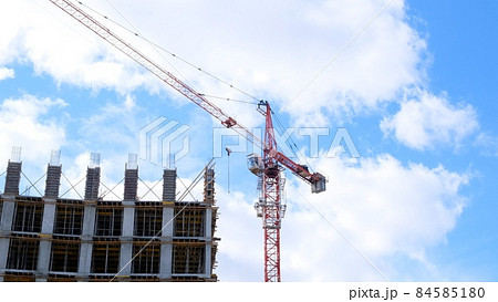 construction crane and unfinished residential buildings against the backdrop of blue sky and construction crane and unfinished residential buildings against the backdrop of blue sky and 84585180