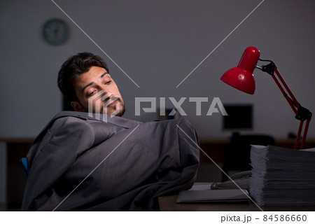 Young male employee working late in the office 84586660