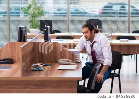 Young male employee and too many work in the office Young male employee and too many work in the office 84586830